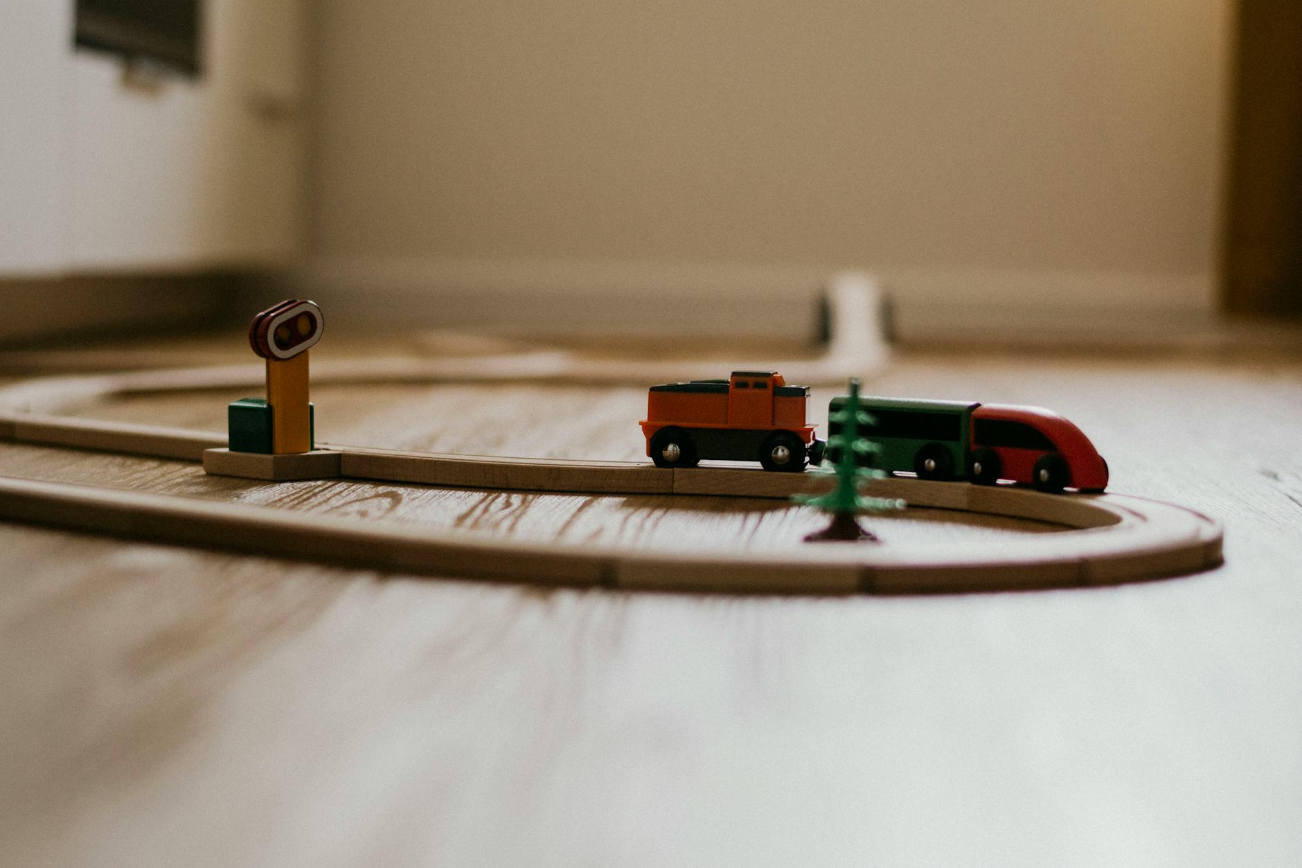 toy trains and railway on wooden flooring